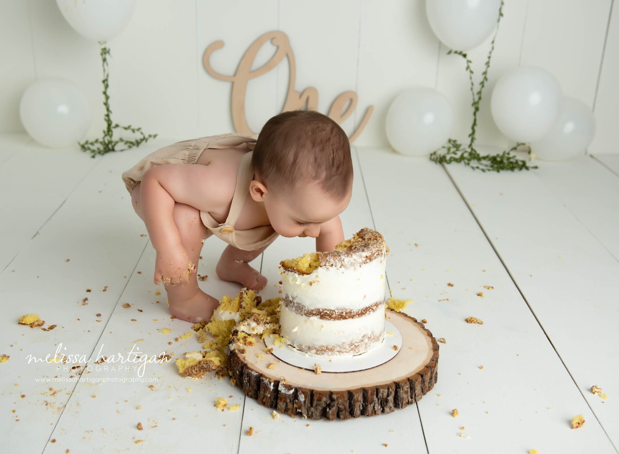 baby boy digging into cake for milestone photography cake smash session