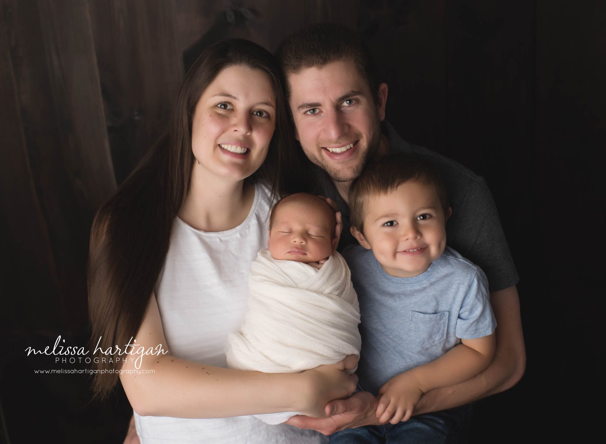 newborn baby boy pose din family picture with mom dad and big brother Connecticut newborn photography