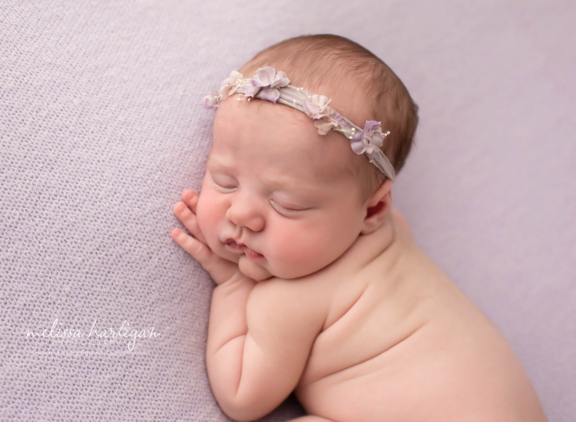 newborn baby girl posed on side with hand under chin newborn photographer hartford county
