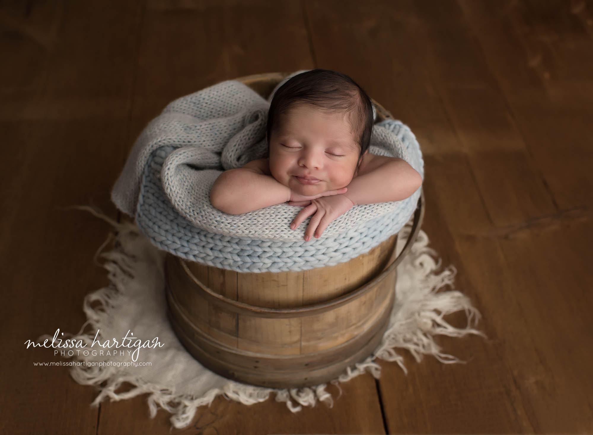 newborn baby boy posed in wooden barrel with light blue knitted wrap newborn photographer CT
