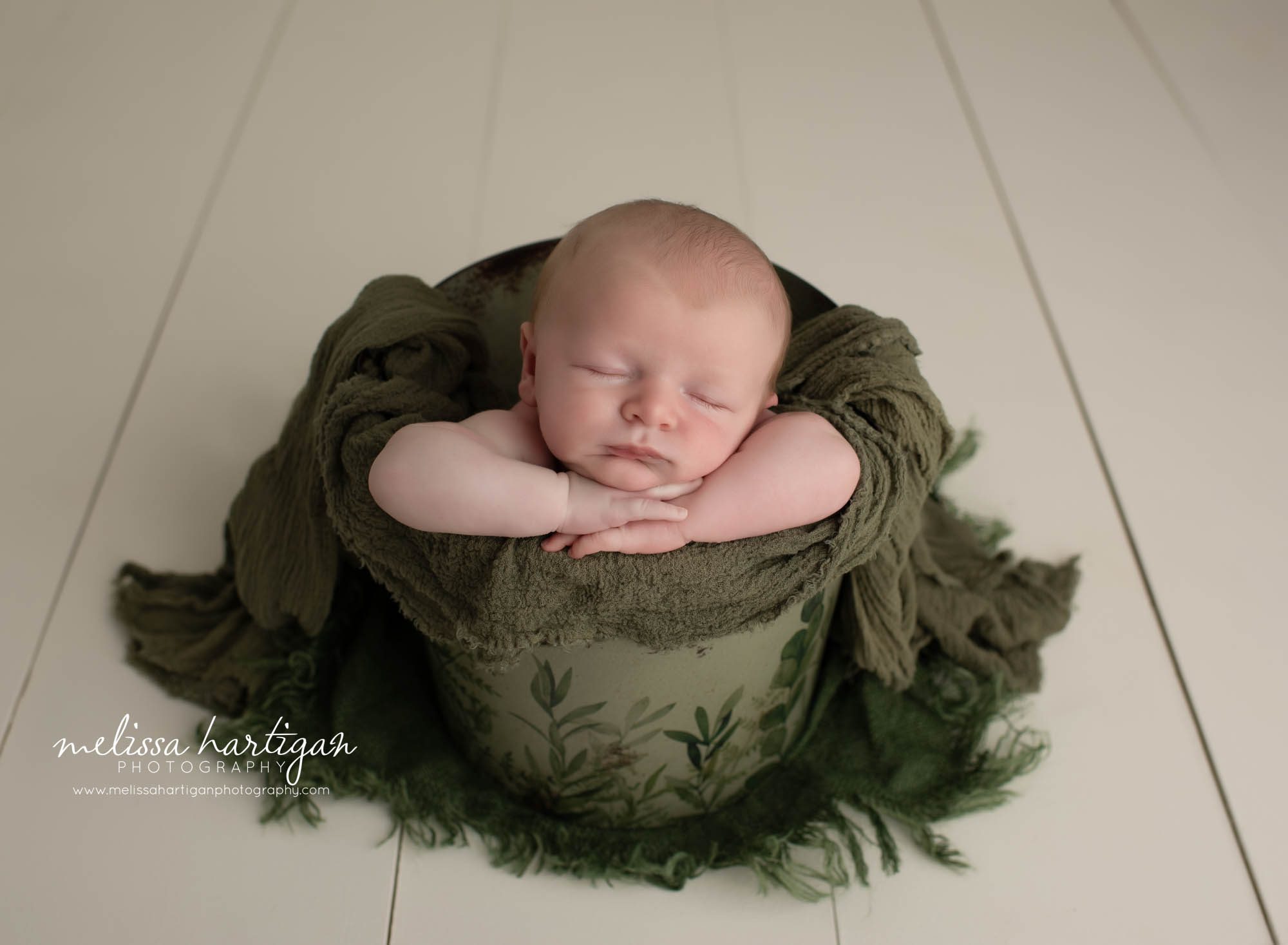 newborn baby boy posed in bucket with green layer wrap newborn photographer CT