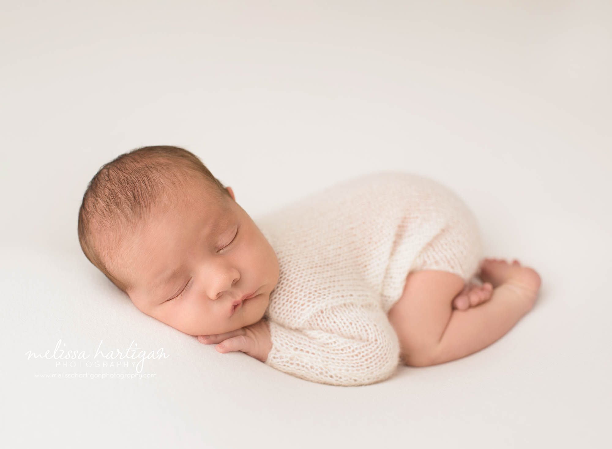 newborn baby boy posed on tummy wearing knitted outfit newborn photography windham county