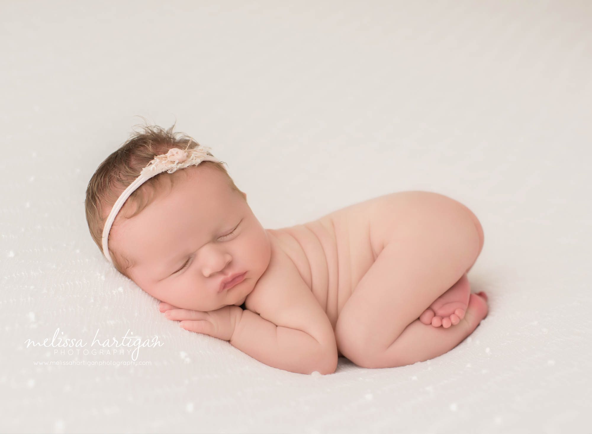 newborn baby girl posed on tummy wearing headband newborn photography windham county