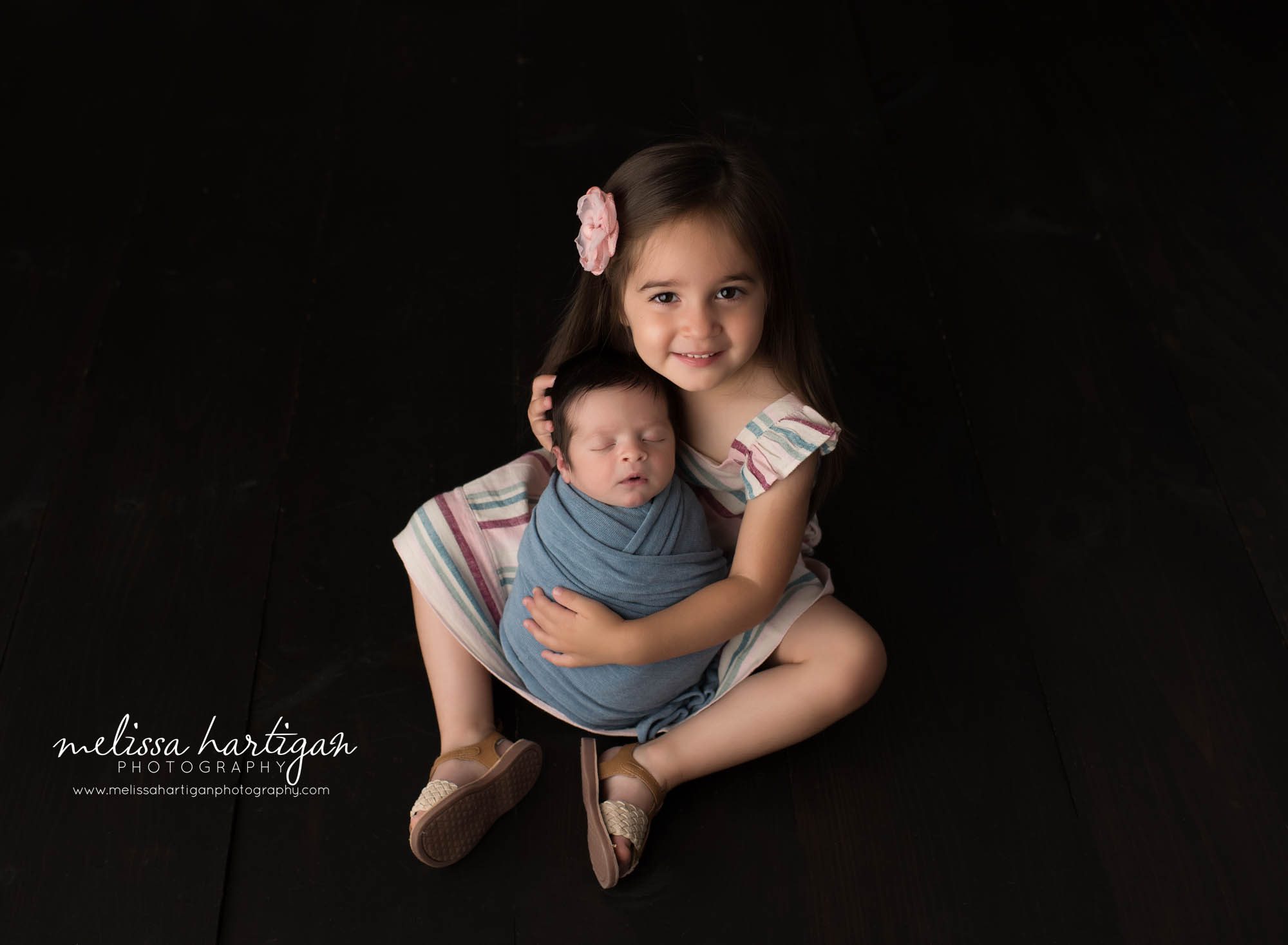 big sister holding newborn baby brother wrapped in blue wrap CT newborn photographer
