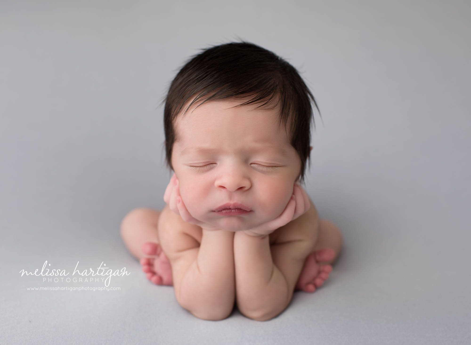 newborn baby boy posed froggy pose on gray backround newborn photography middlesex county