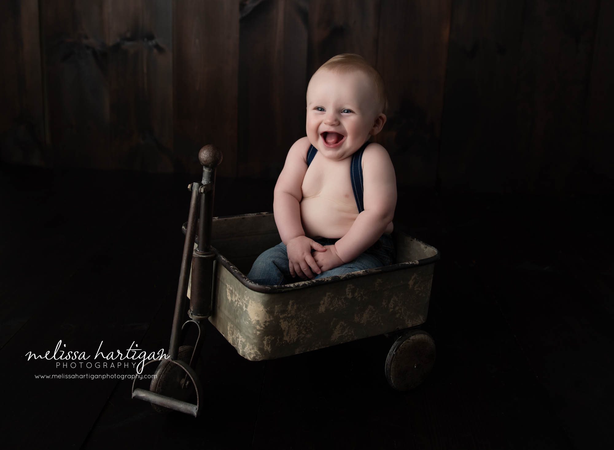 baby boy sitting in metal wagon happy laughing smiling connecticut baby photographer