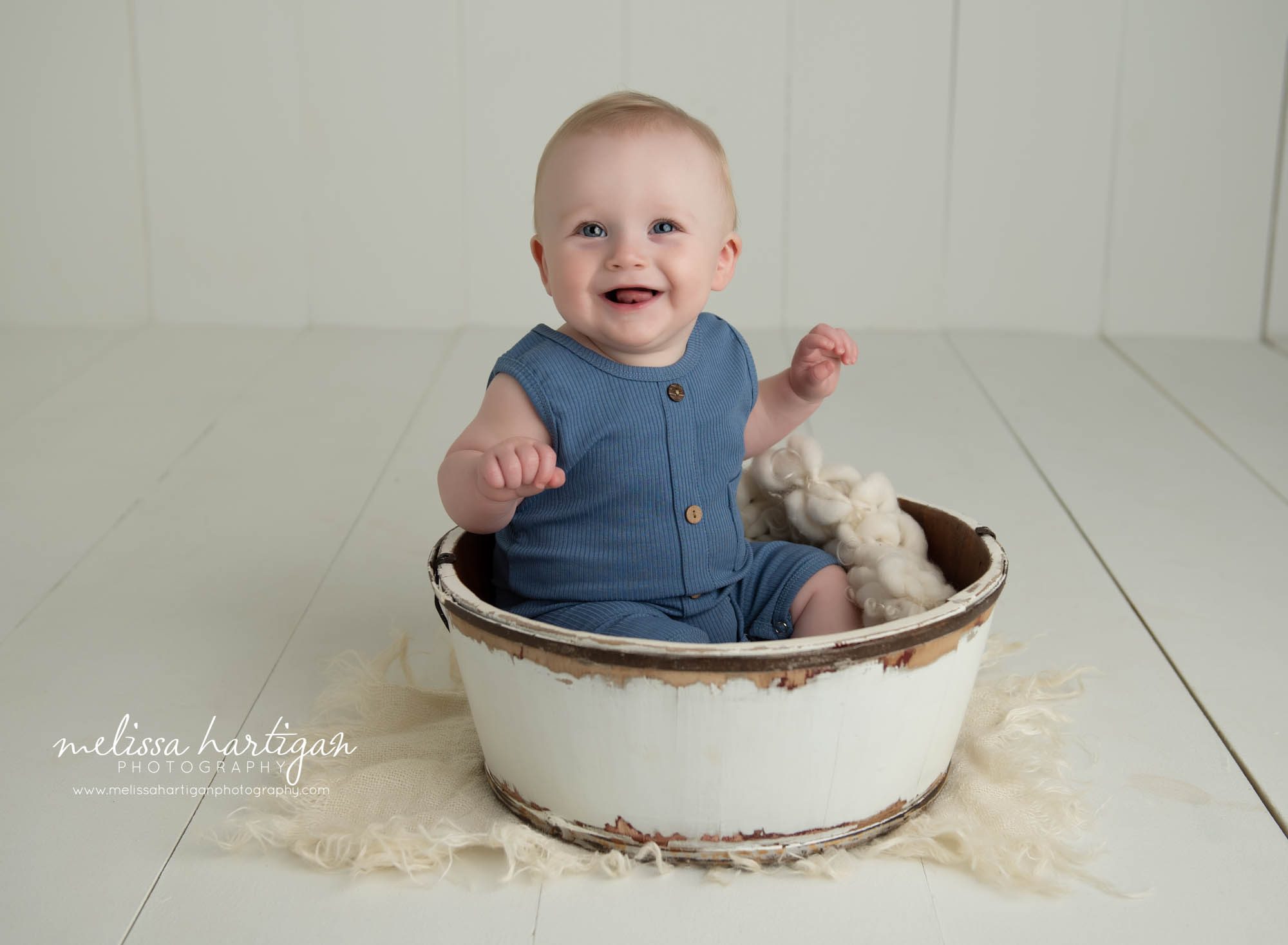 baby boy sitting in white wooden barrel bucket wearing blue baby outfit tolland county CT baby photographer