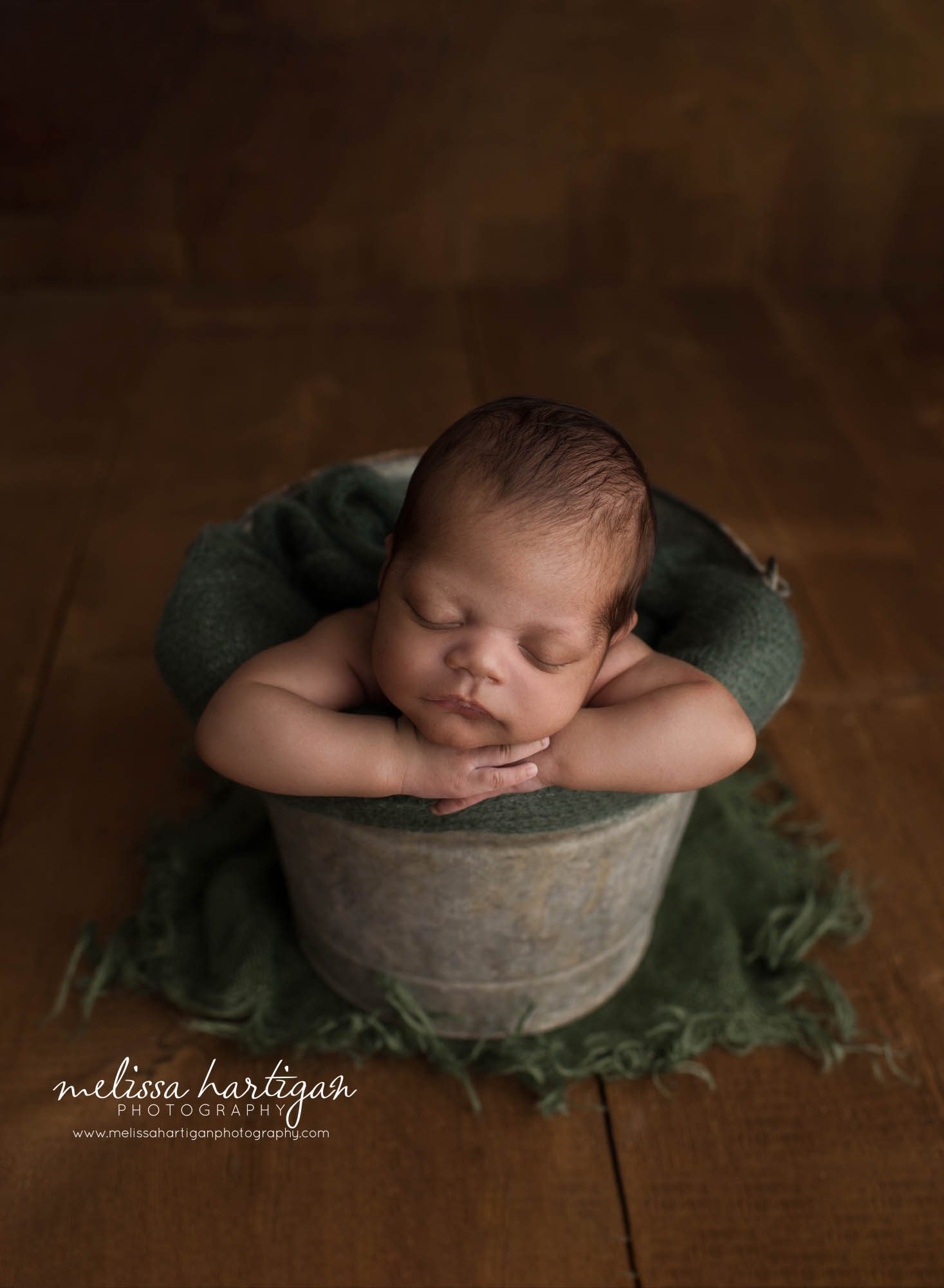 newborn baby boy posed in bucket with green layer wrap CT newborn photographer