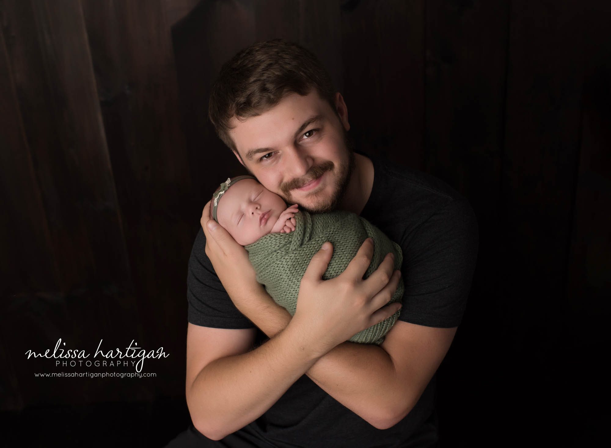 dad holding newborn daughter in parent pose CT newborn photography session