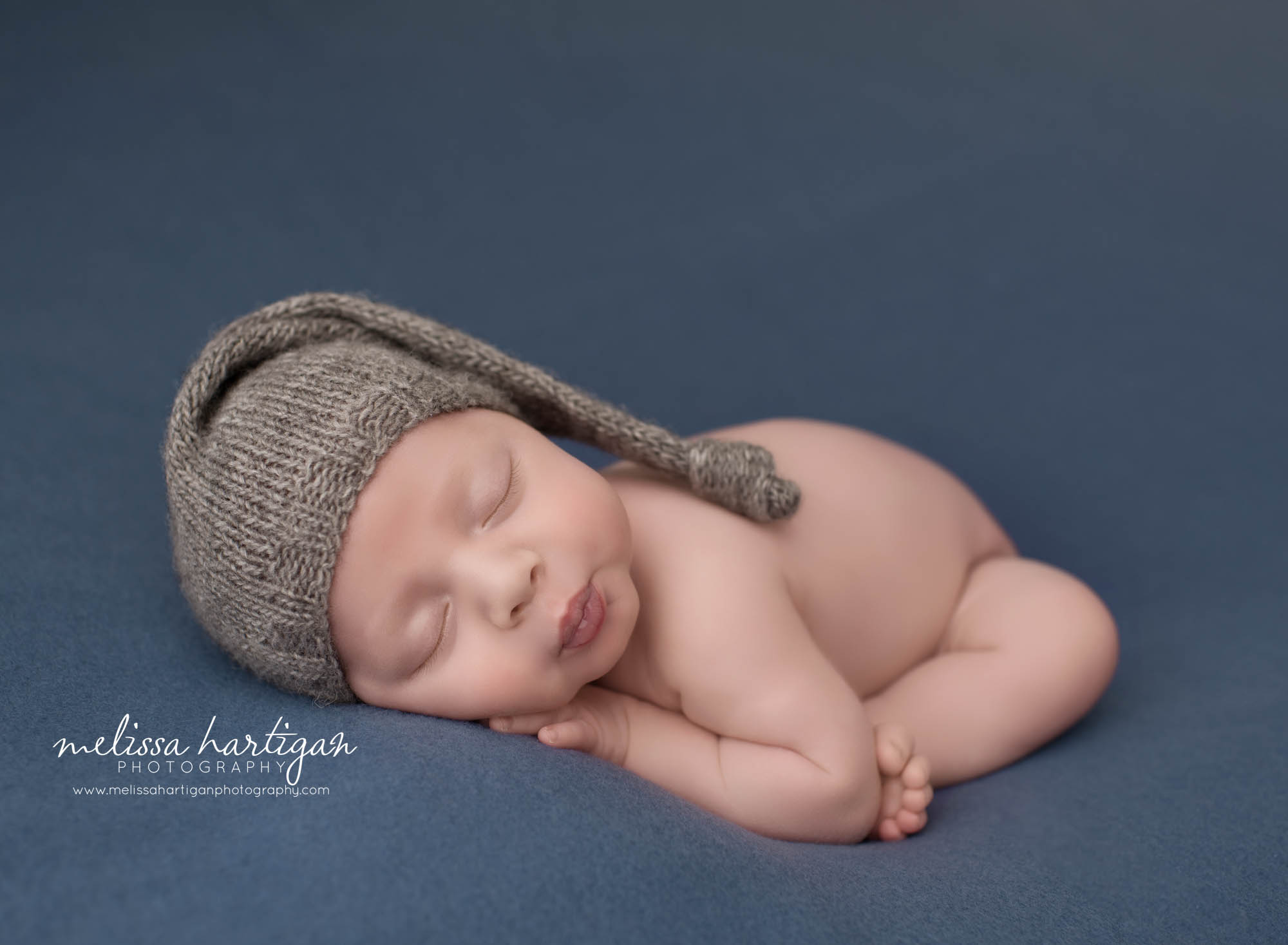 newborn abby boy posed on side tummy wearing sleepy cap newborn Photography unionville CT