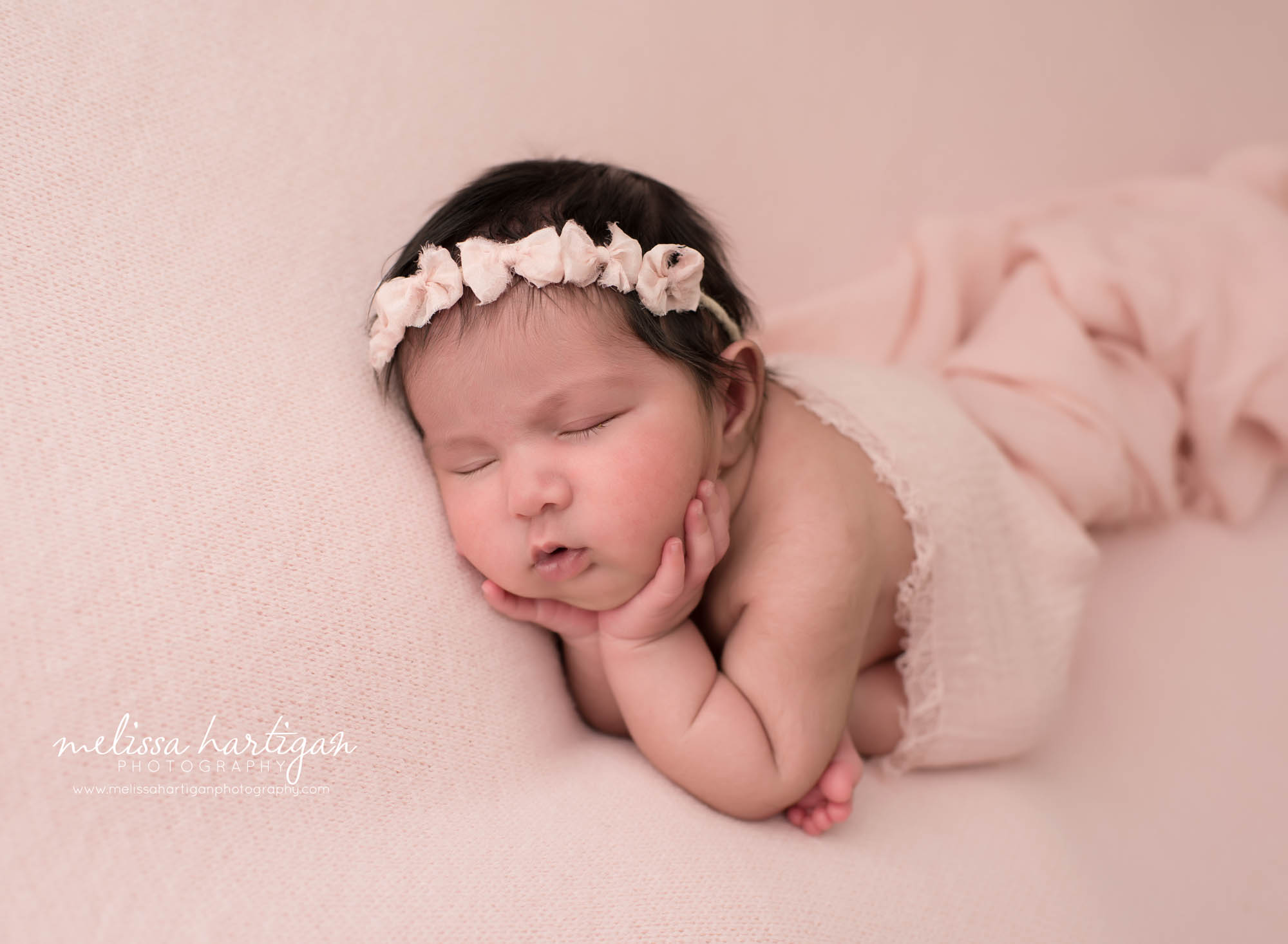 newborn baby girl posed in pink backdrop wearing pink bow headband baby photography brandford ct