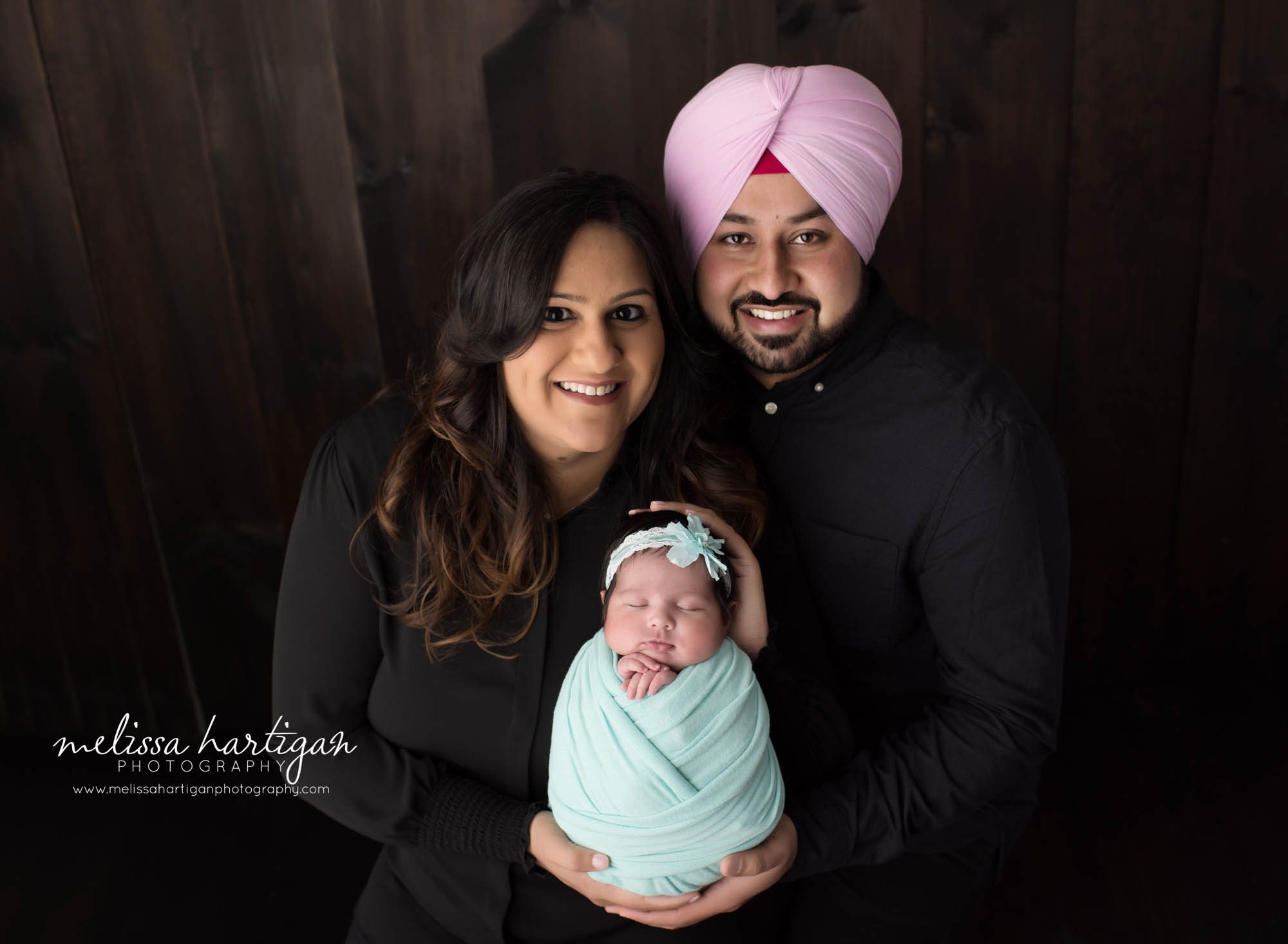 mom dad holding baby daughter in parents pose family