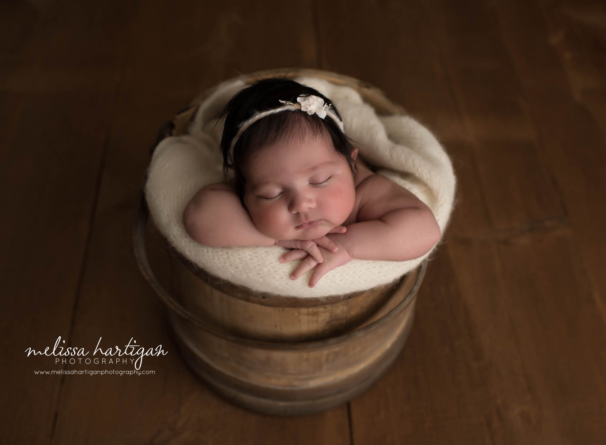 newborn baby girl posed in wooden barrel sleeping with cream knit layer branford ct baby photographer