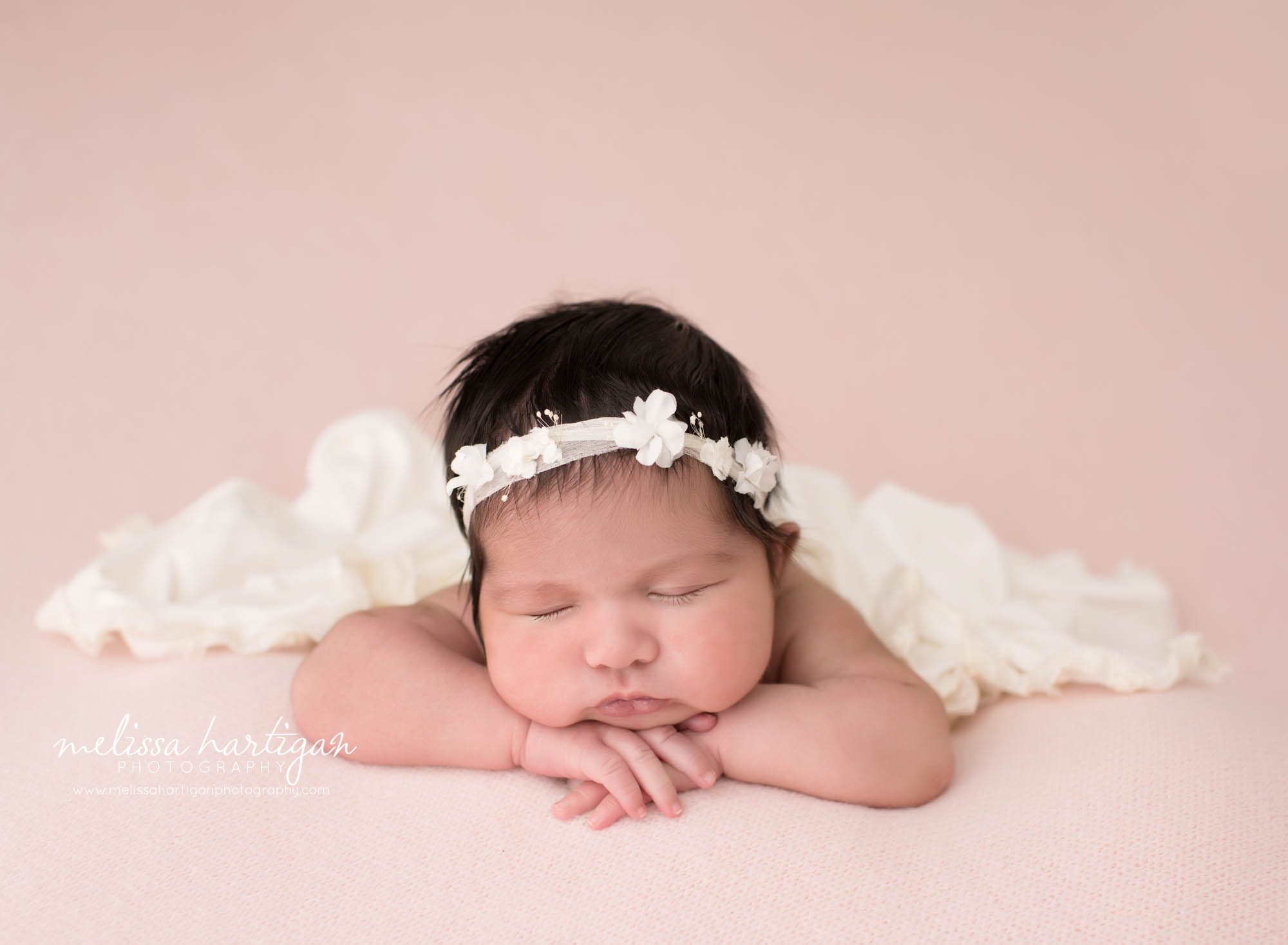 newborn baby girl posed on pink backdrop with white cream layer wearing headband Branford CT baby photography