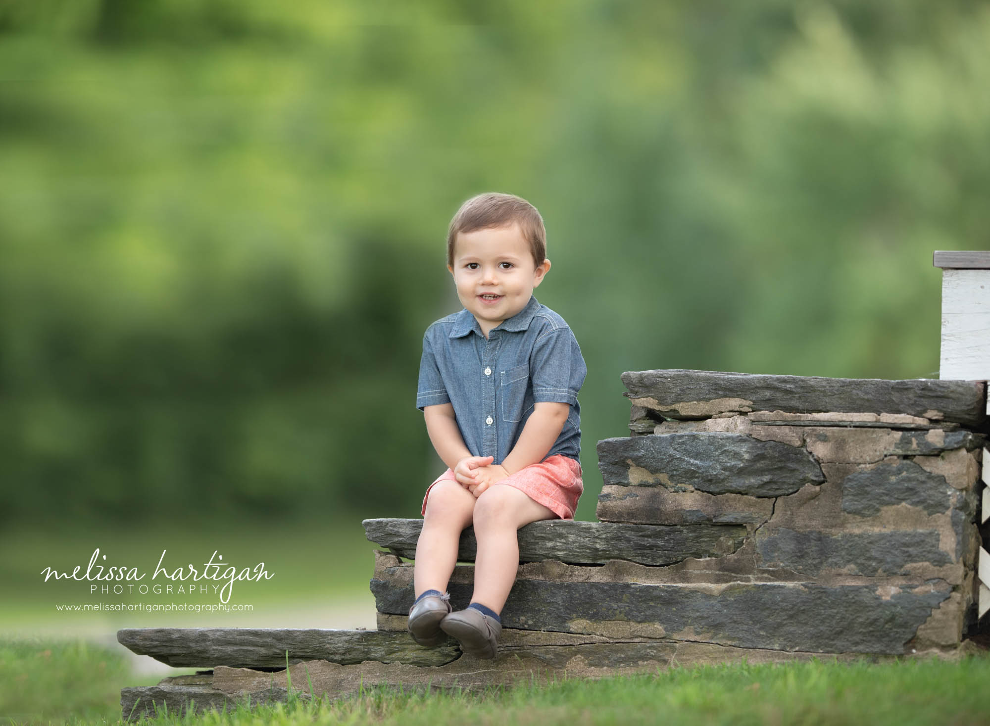 little boy sitting on rocks in park CT children photography