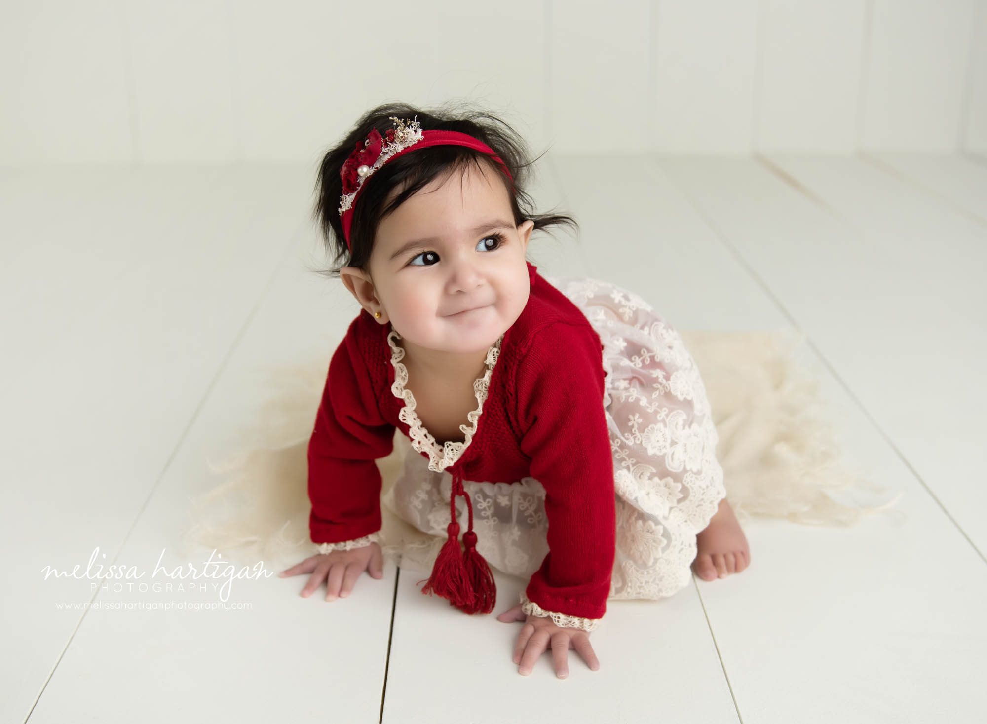 baby girl crawling on wooden boards in studio photography session