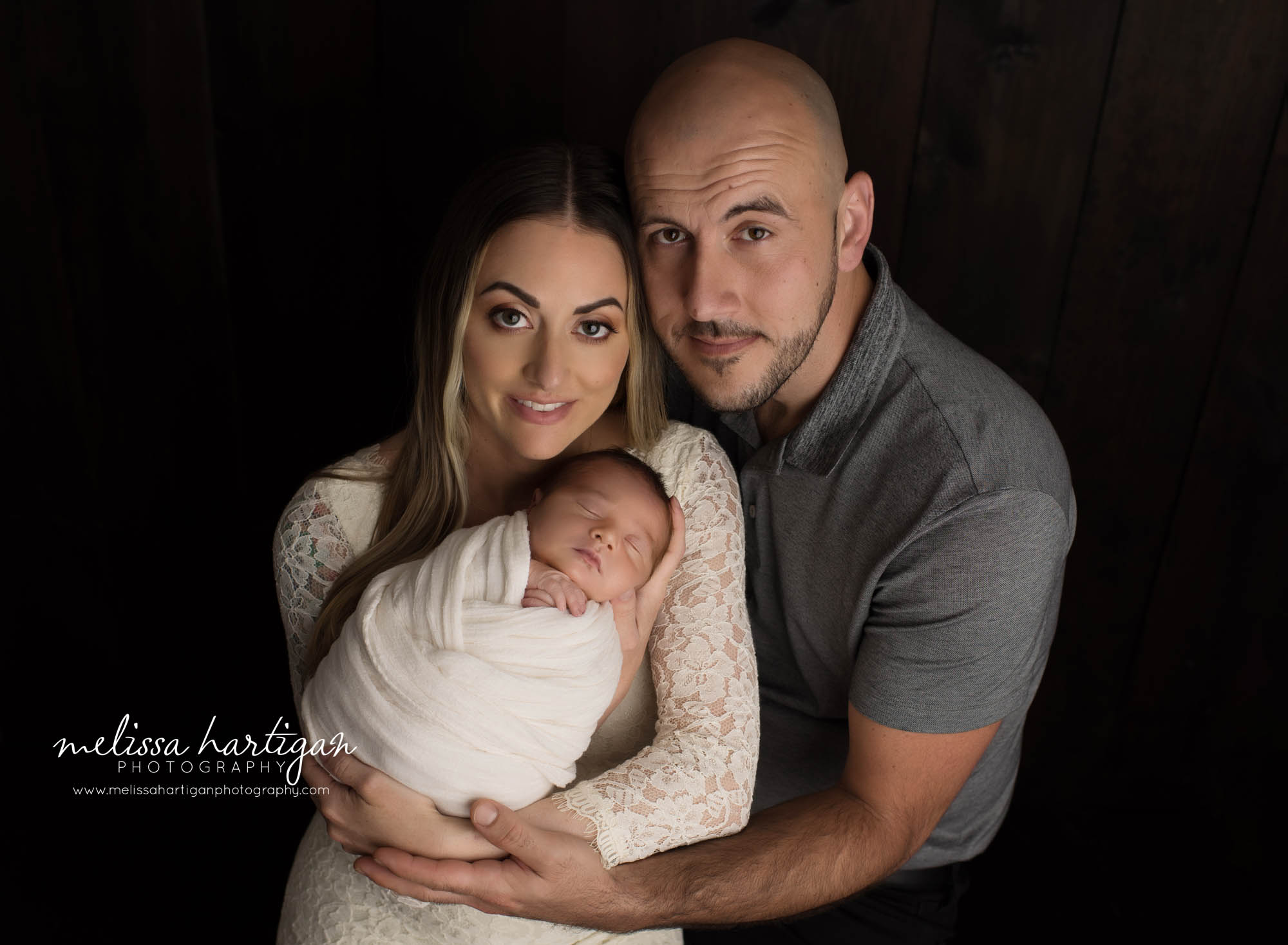 mom dad holding newborn son parents family pose newborn photographt CT photoshoot
