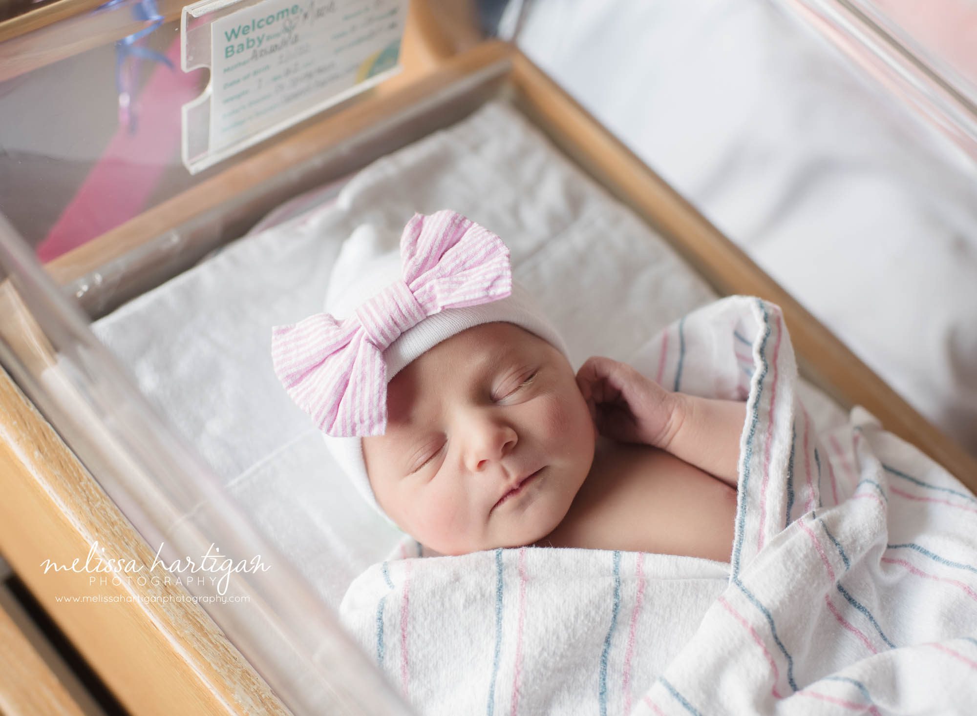newborn baby girl swaddled in hospital bassinet