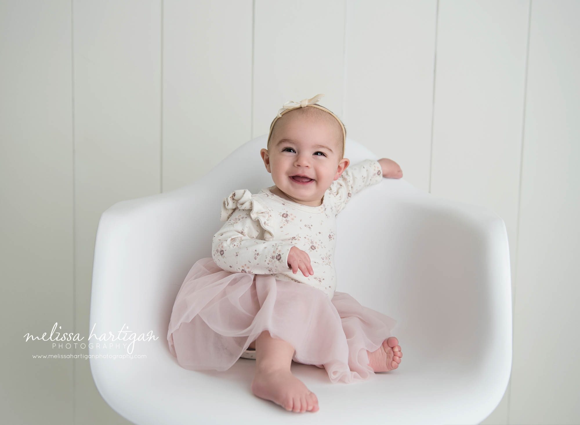 baby girl sitting on chair smiling south windsor baby photography