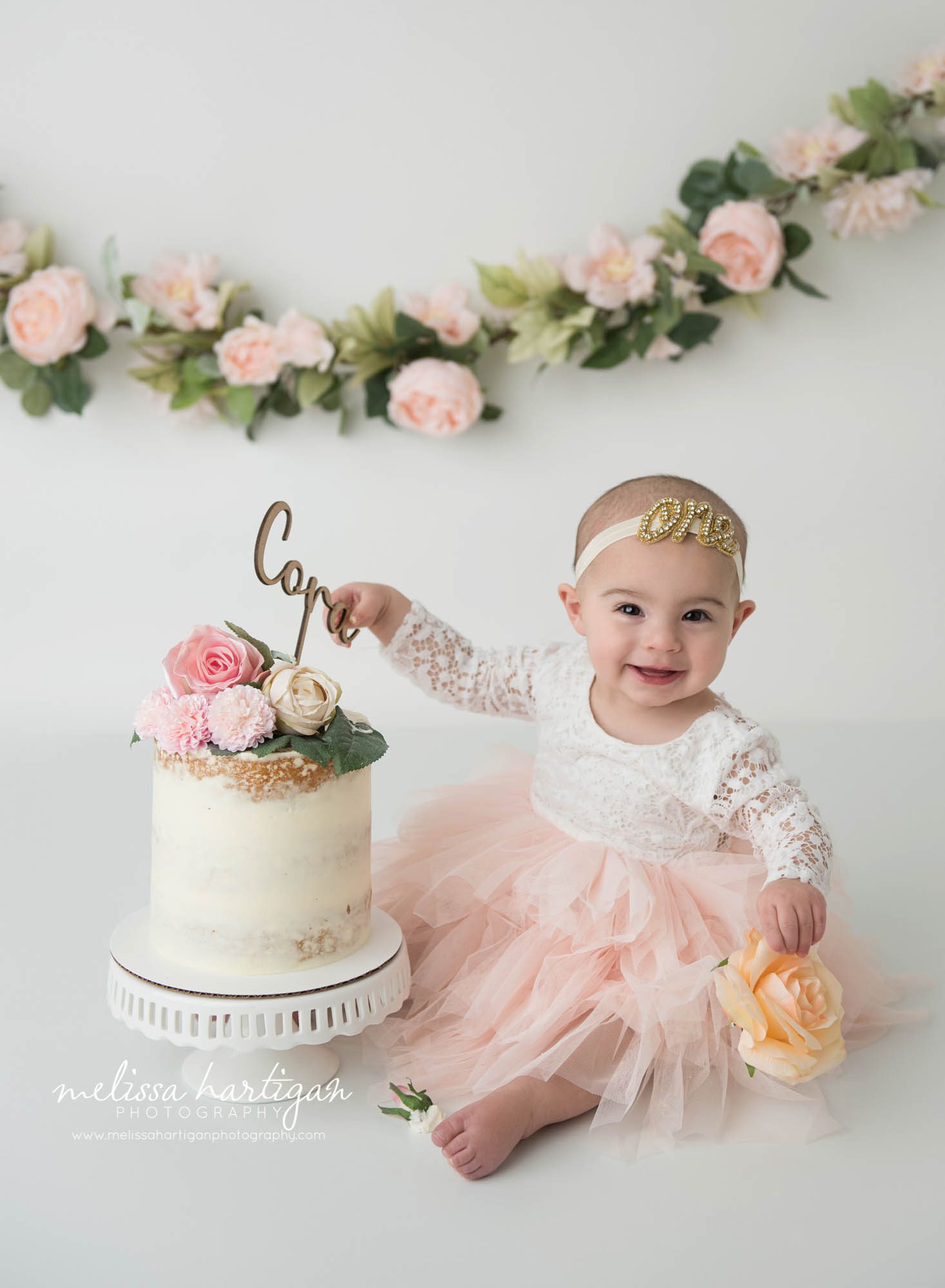 happy baby girl sitting next to her birthday cake CT milestone photographer