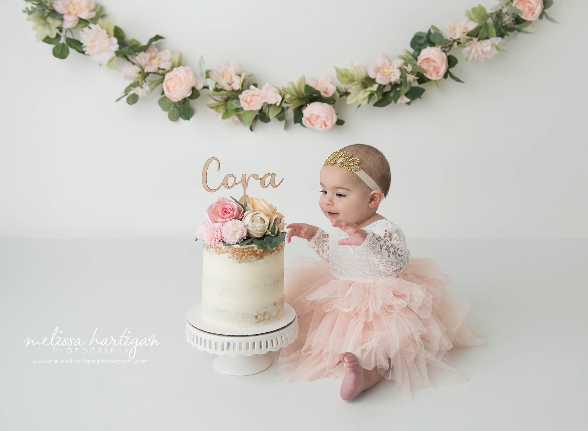 baby girl sitting next to cake smash cake CT baby phbotography