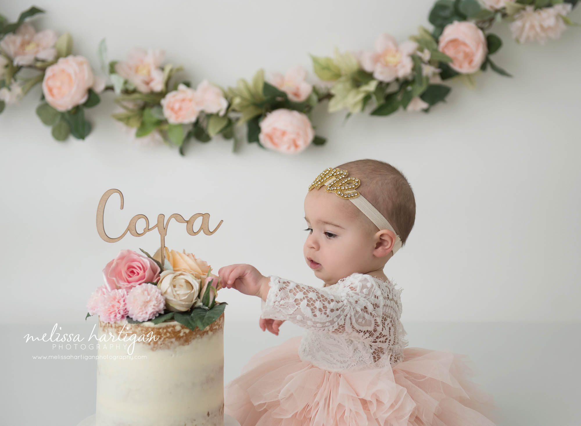 baby girl looking at cake smash cake
