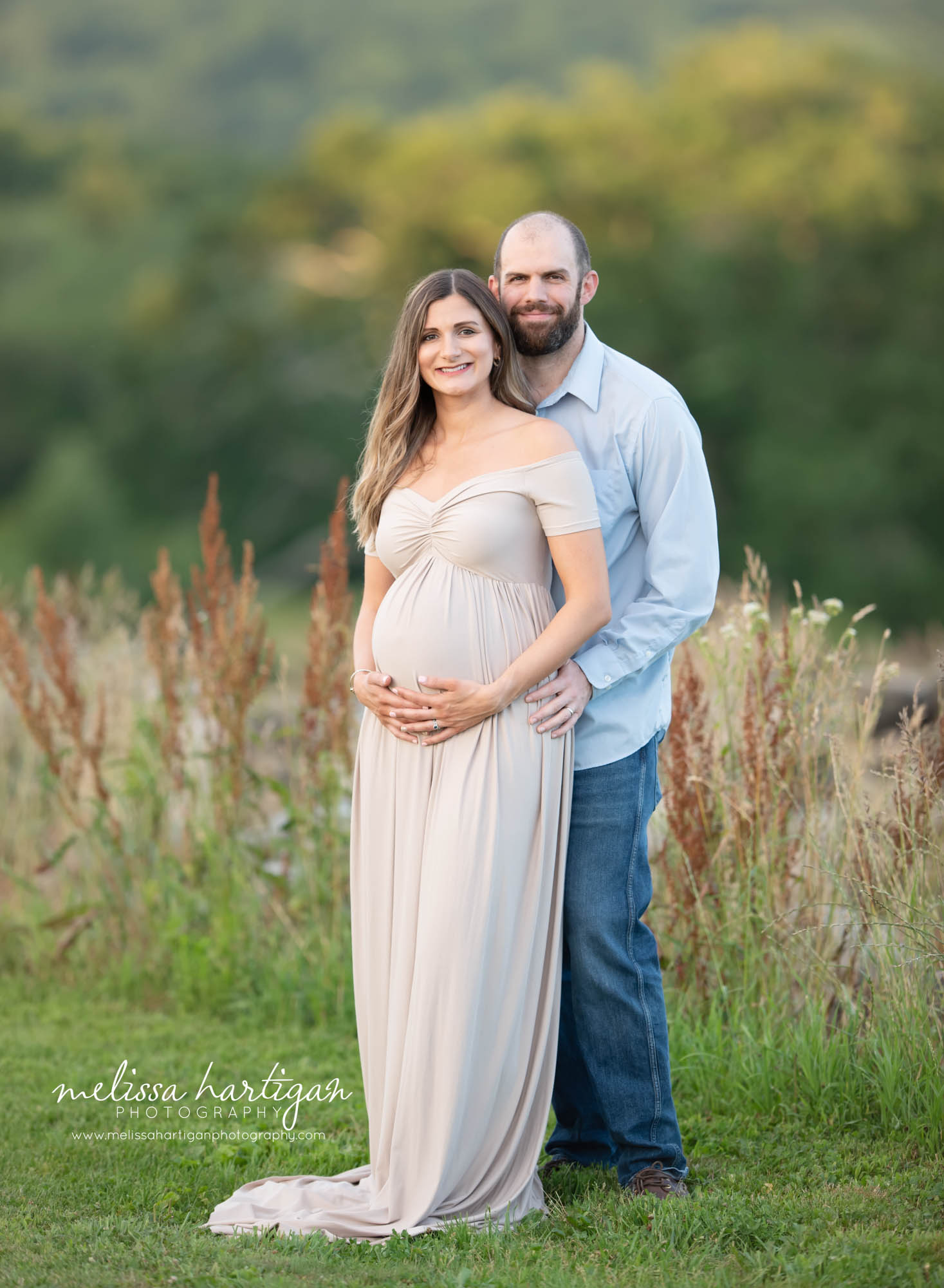 expecting couple standing together for couples pose outside maternity session