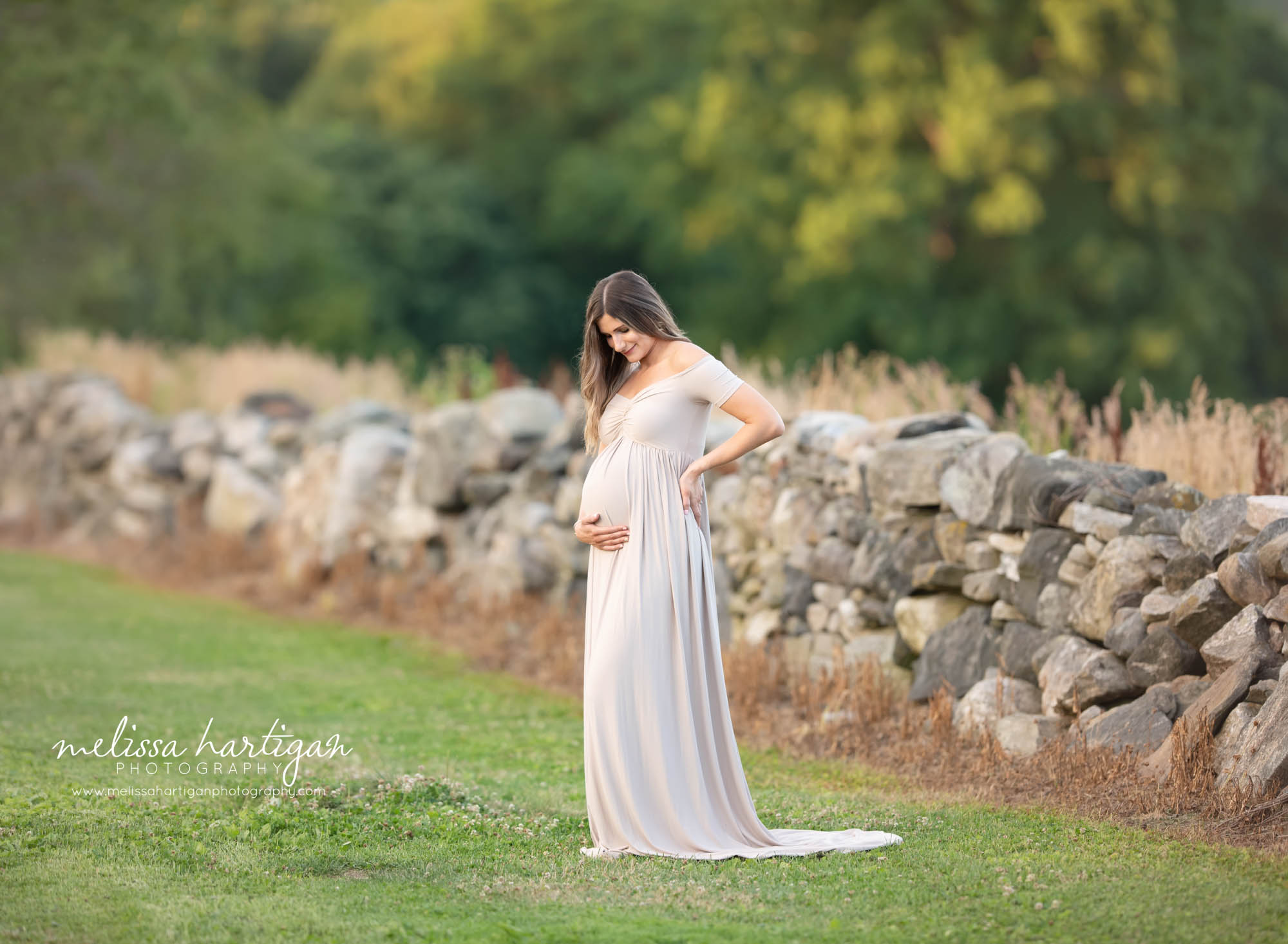 pregnant mom to be wearing long maternity gown holding baby bump CT maternity photography