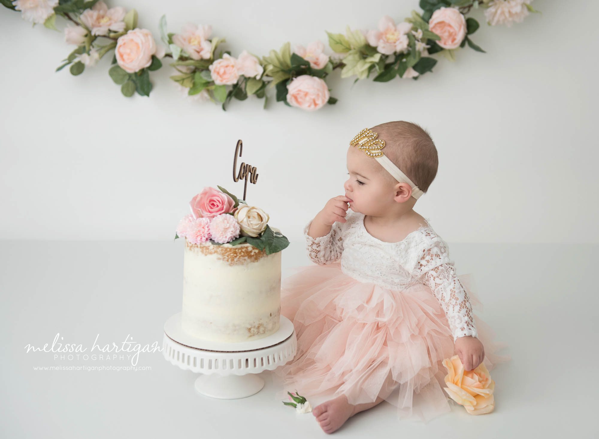 baby girl tasting cake from cake smash photography CT session