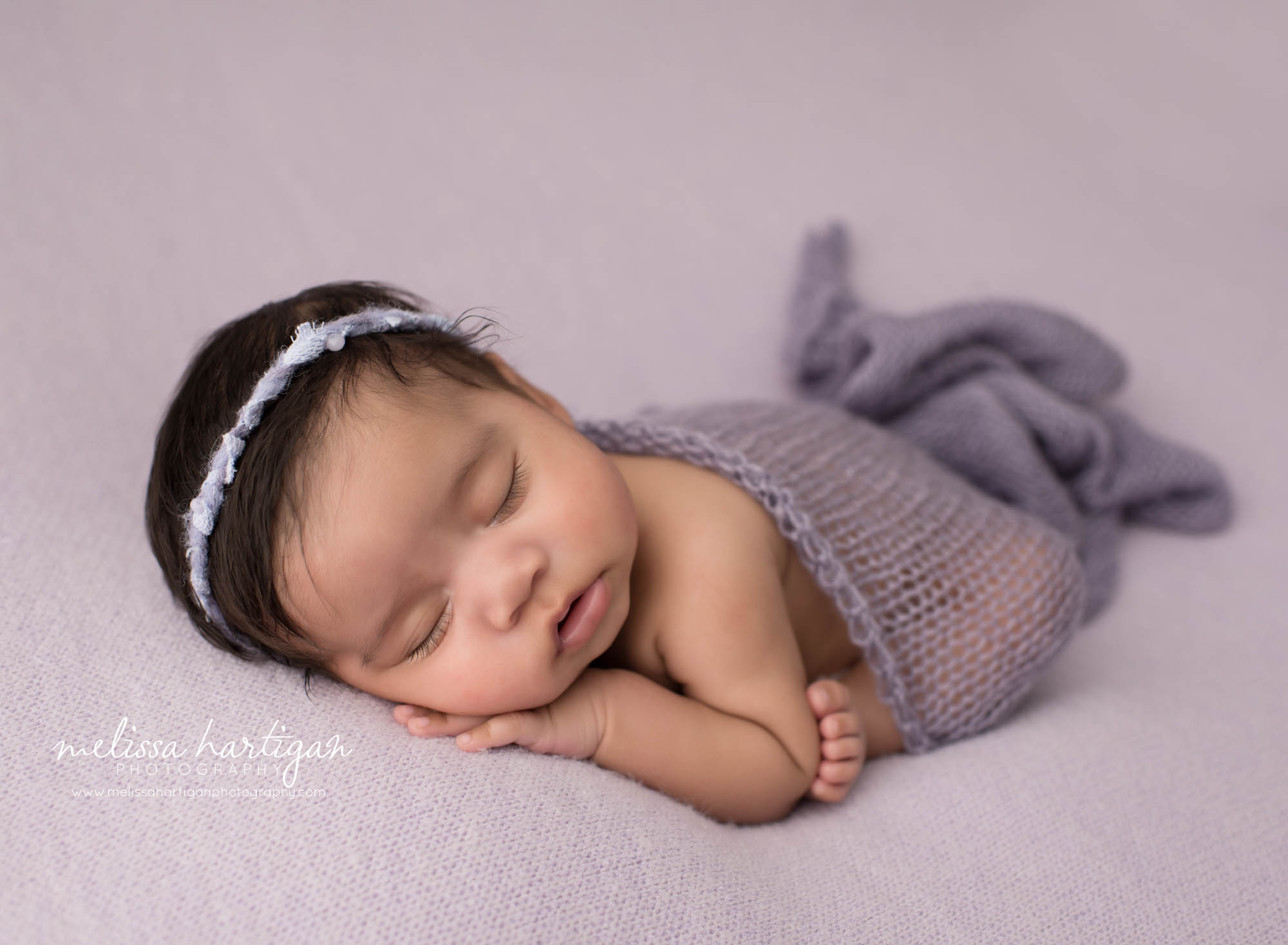 newborn baby girl posed on purple backdrop modified taco pose north haven county newborn photography