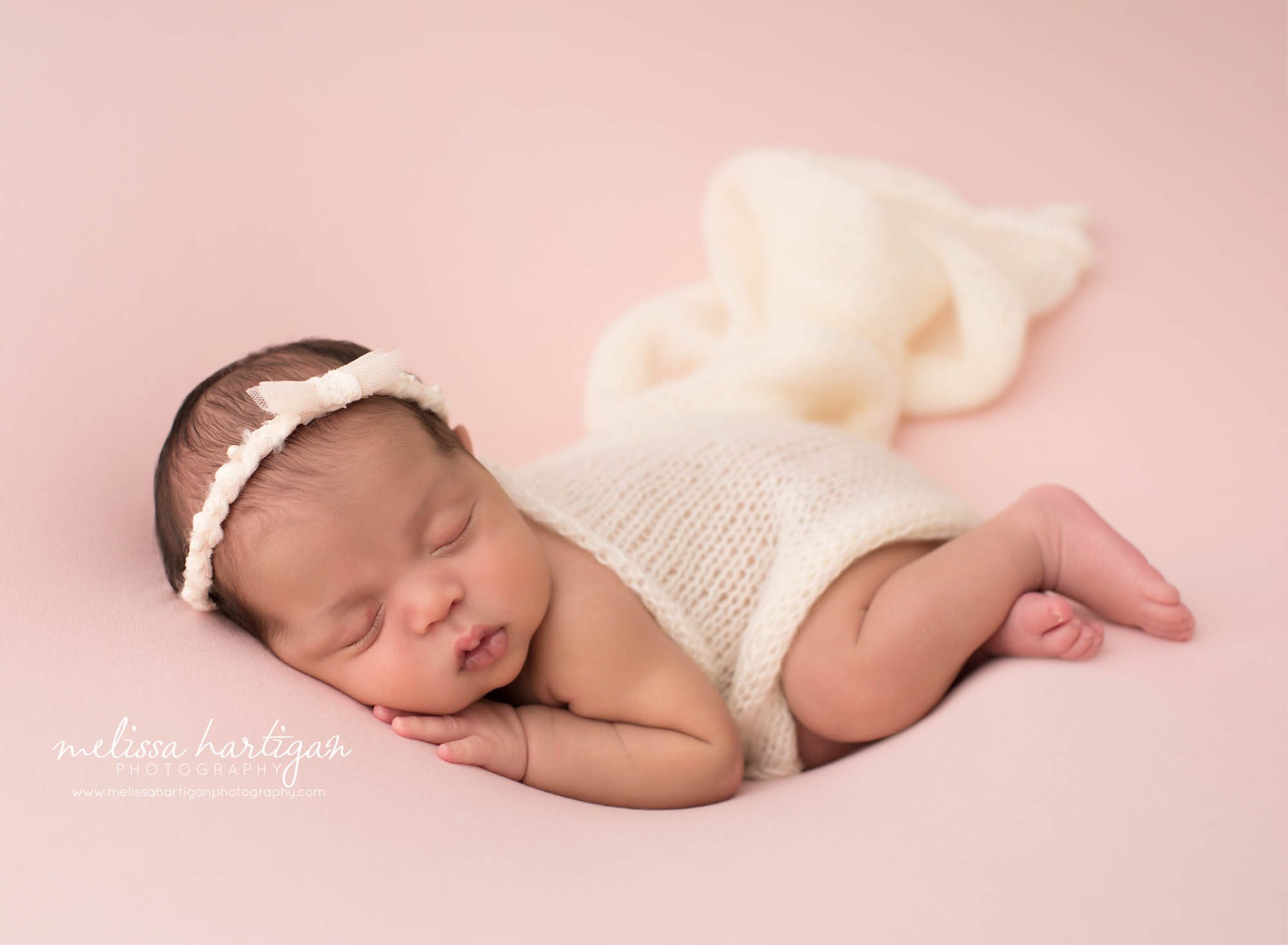 newborn baby girl posed on side with cream knitted layer draped over backside sleeping hartford county newborn photography CT