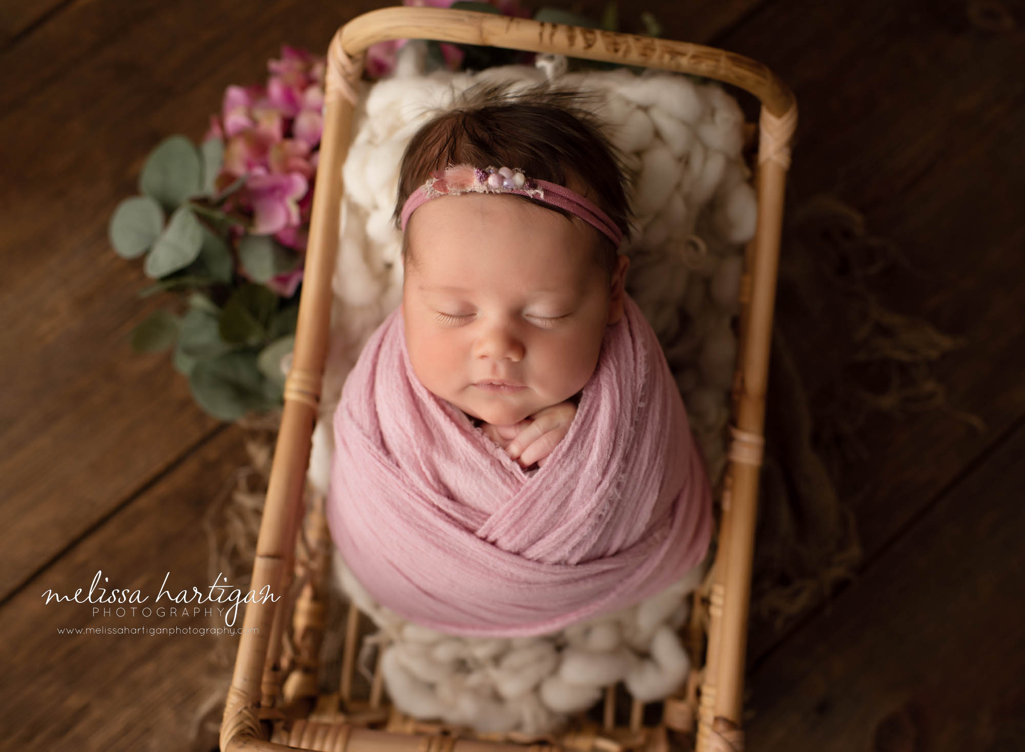 newborn baby girl wrapped in pink wrap posed in basket CT newborn photography