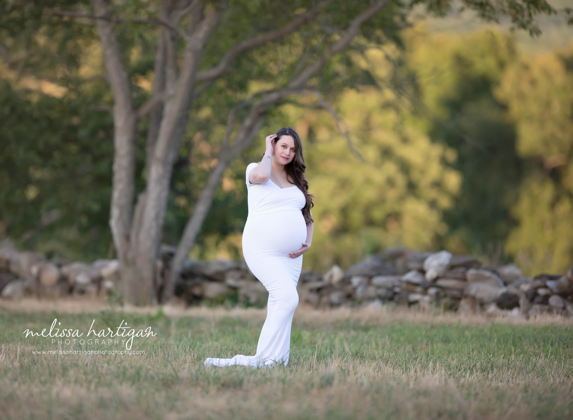 mom-to-be wearing white gown holding baby bump maternity photographer CT