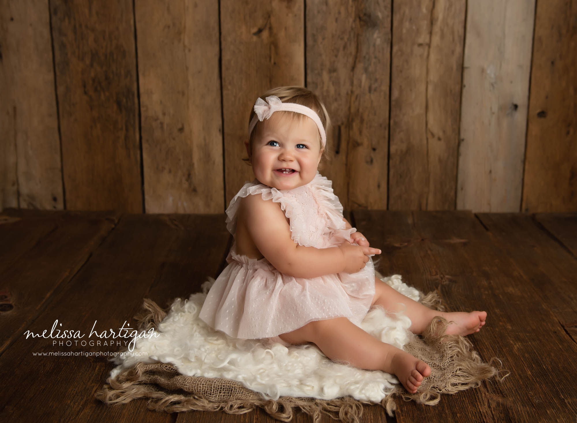 baby girl sitting on curly fluff layer in baby photography studio hartford county baby photographer