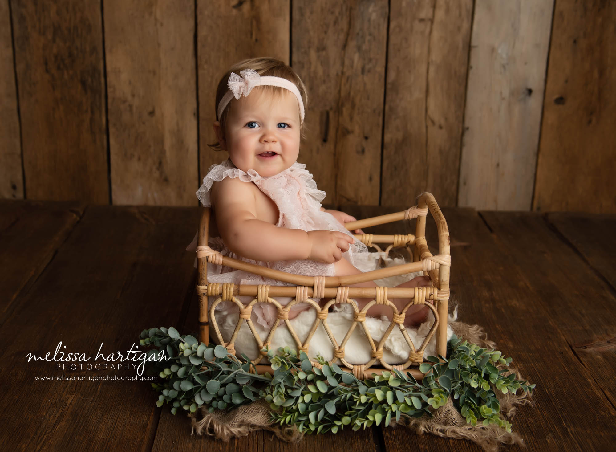 baby girl sitting in studio basket photography prop