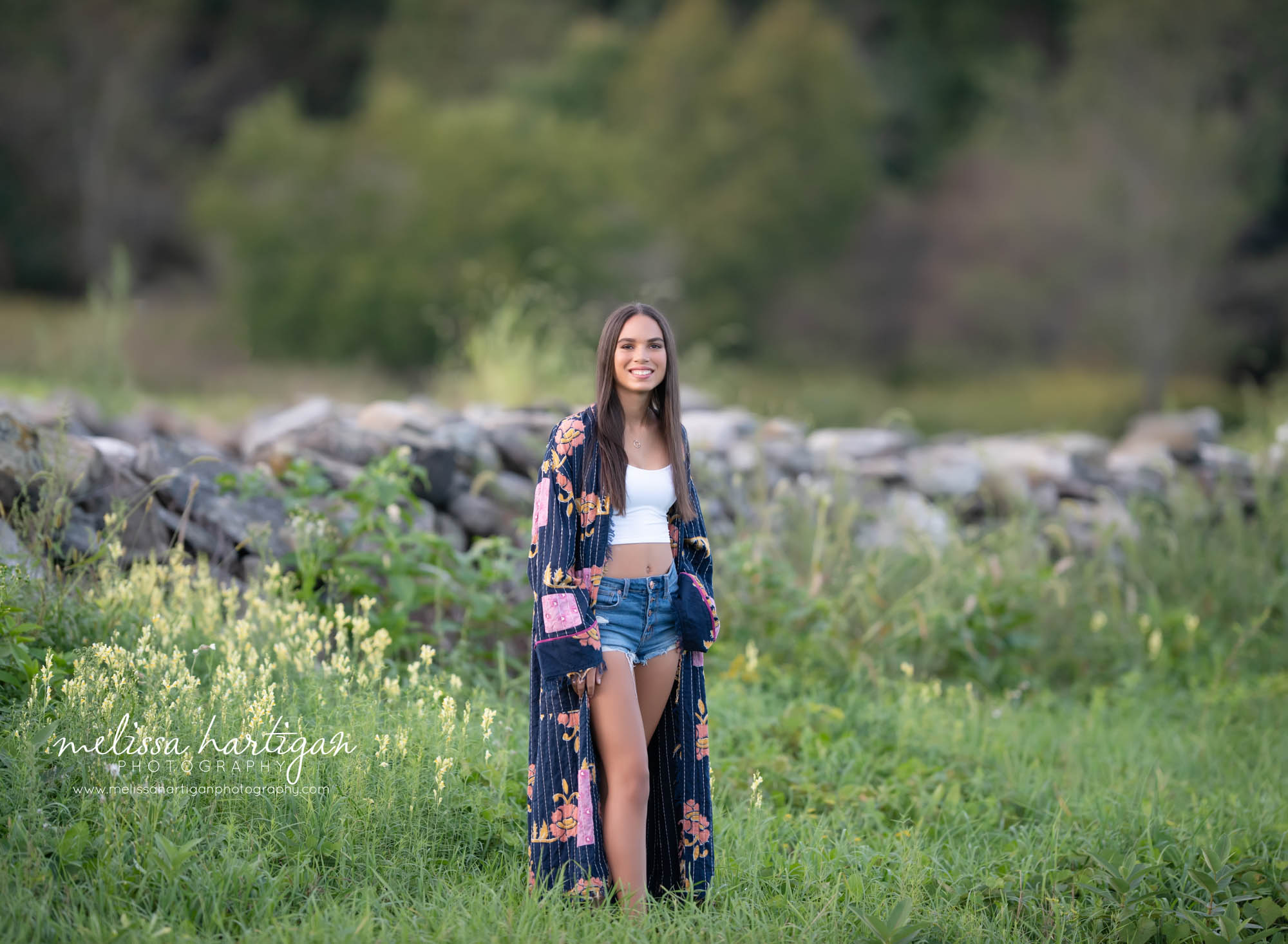 teenage girl standing in field smiling happy