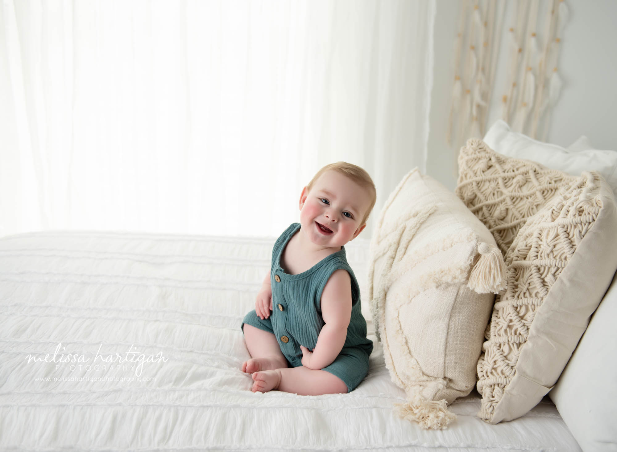 happy smiley baby boy sitting on bed being cute unionville ct baby photography