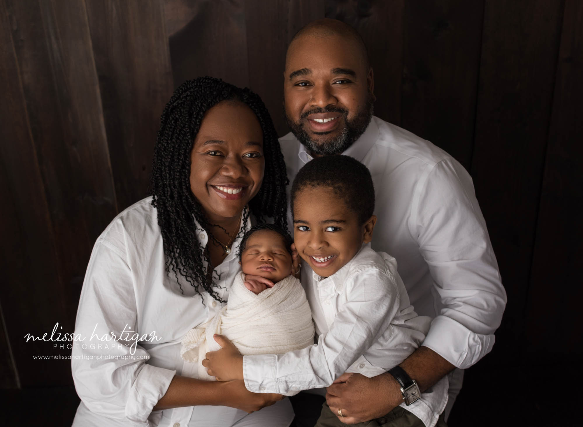 mom dad big brother and new baby boy wrapped in cream wrap family pose ct newborn photographer