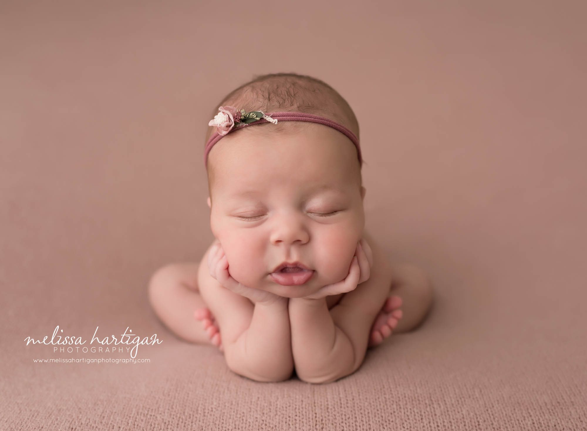 newborn baby girl posed froggy pose on rose pink backdrop