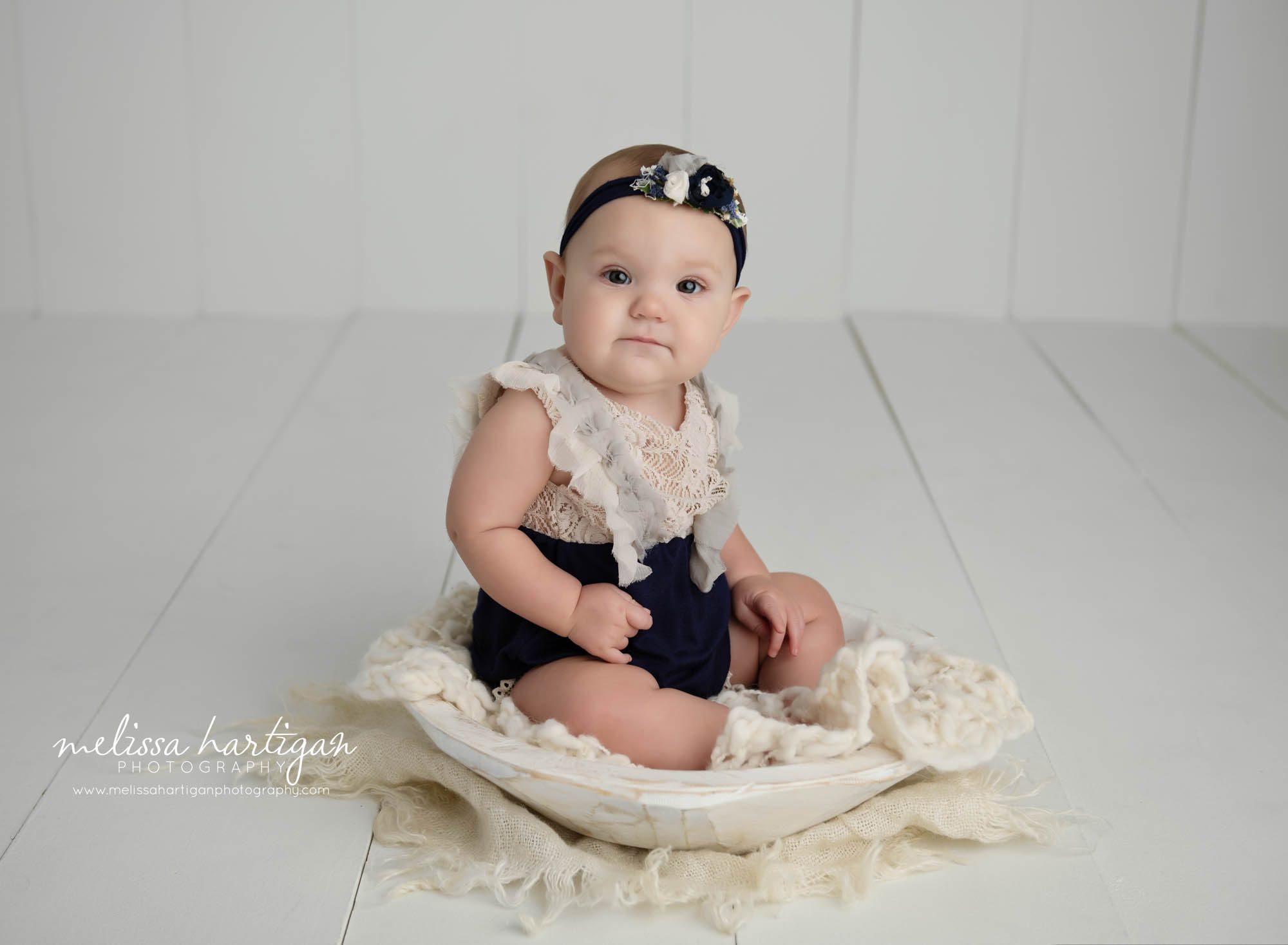 baby girl sitting in cream colored wooden bowl prop baby milestone photography studfio