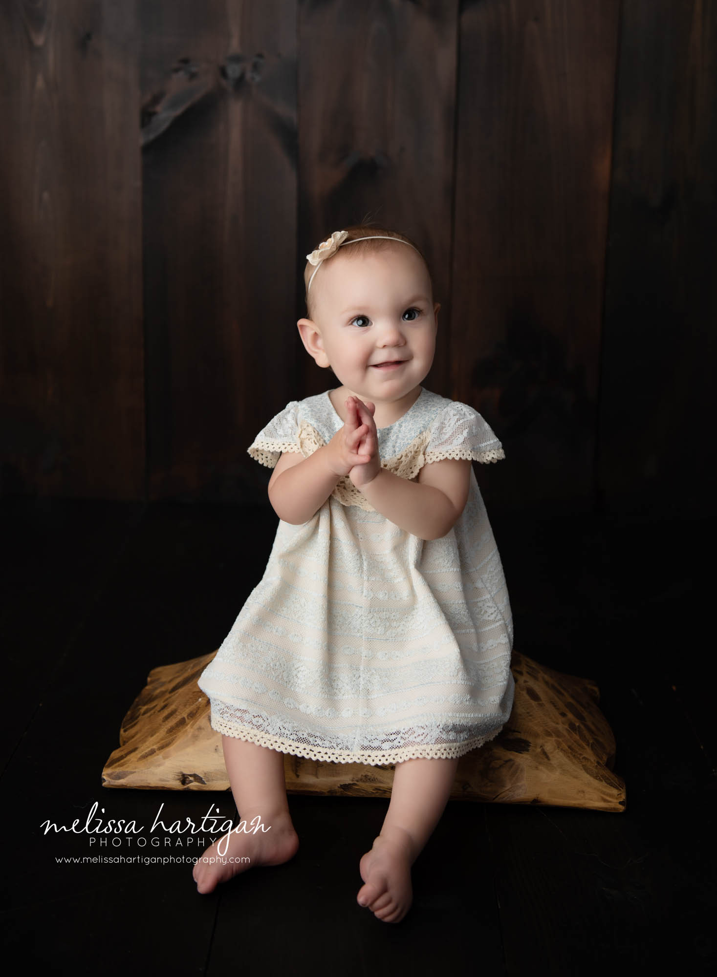 happy baby girl clapping hands sitting on wooden prop storrs mansfield baby photographer