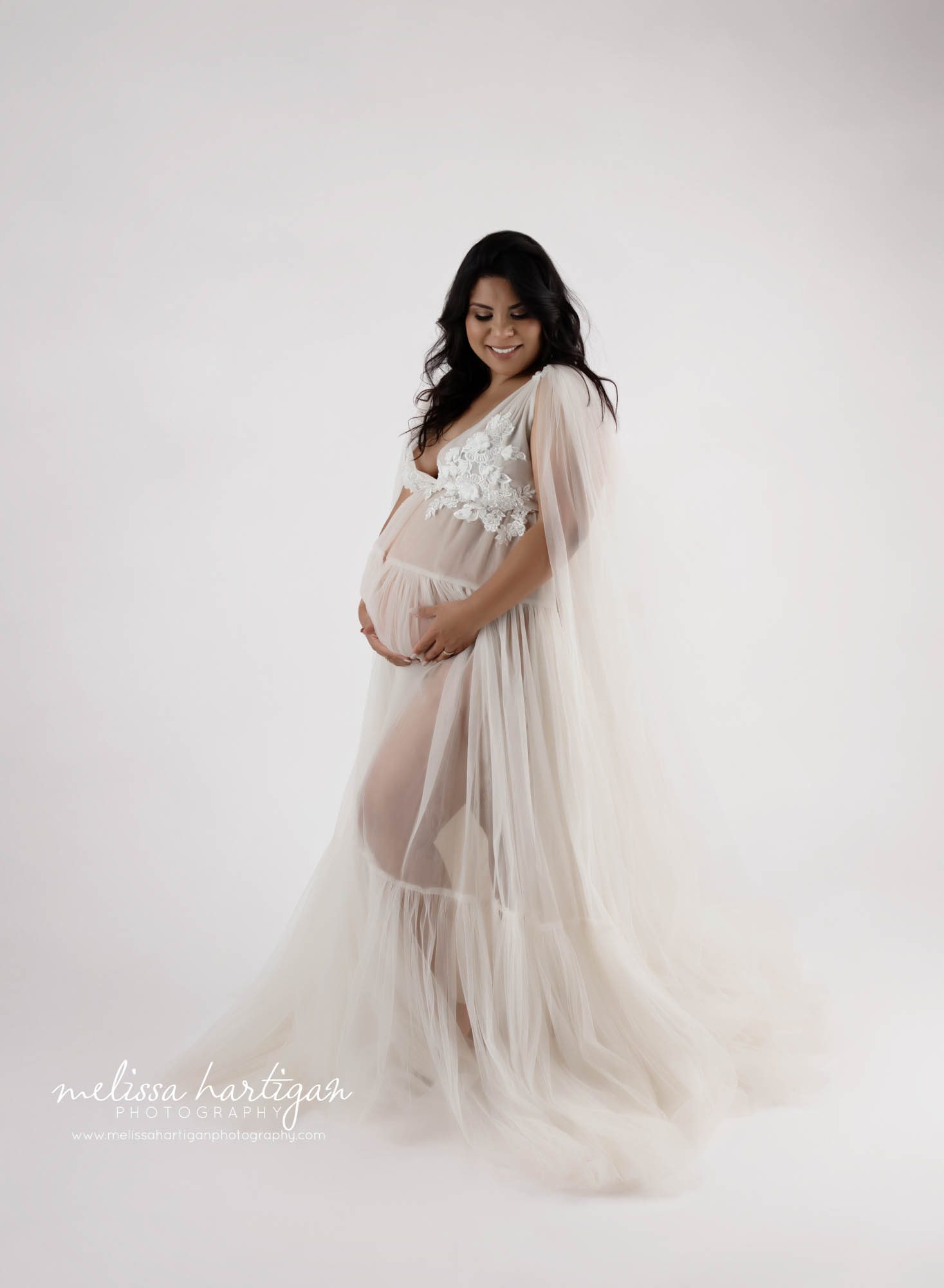 pregnant mom wearing sheer long maternity dress with lace holding pregnant baby bump hartford county maternity photography