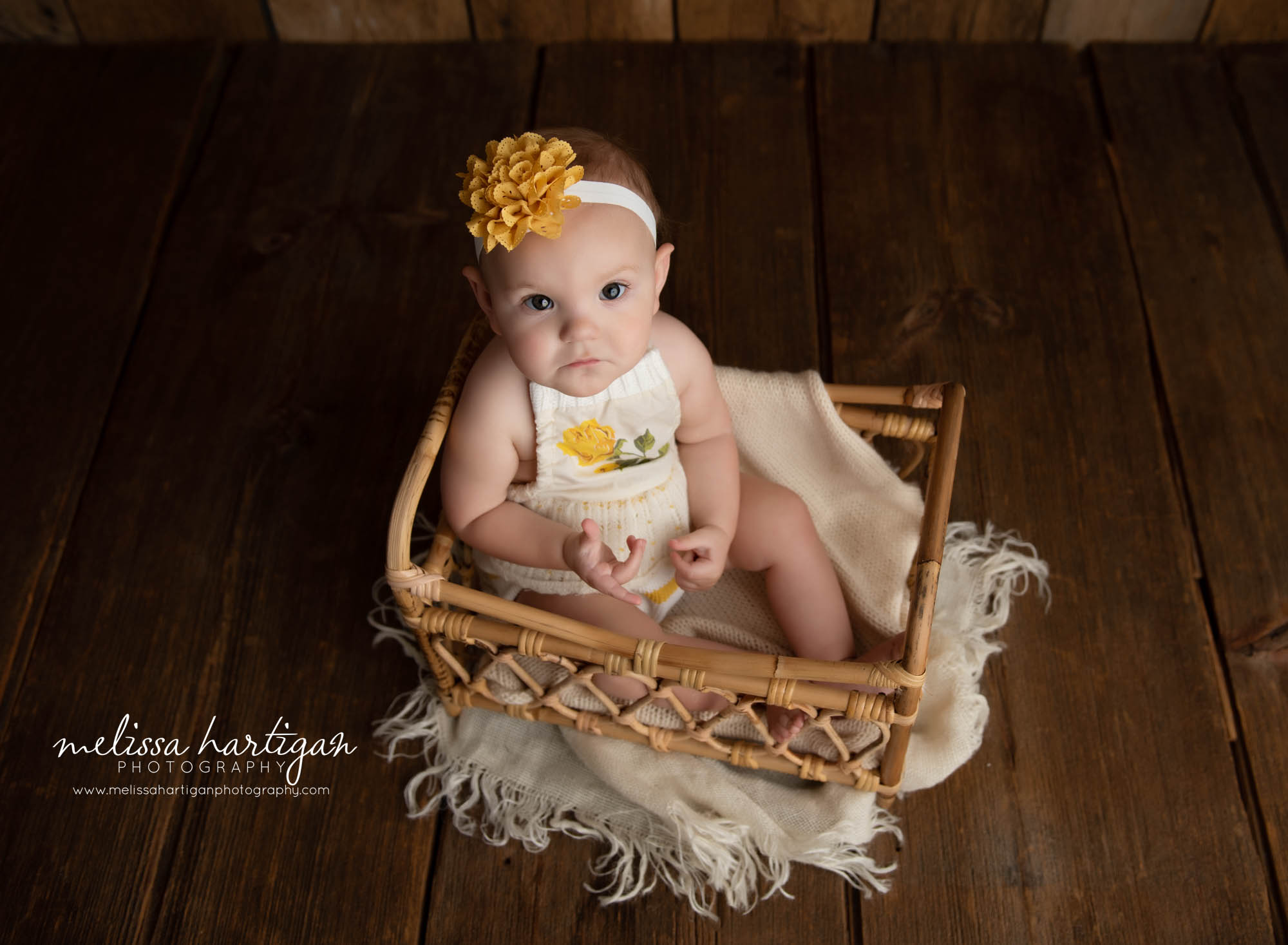 baby girl sitting in basket wearing baby outfit