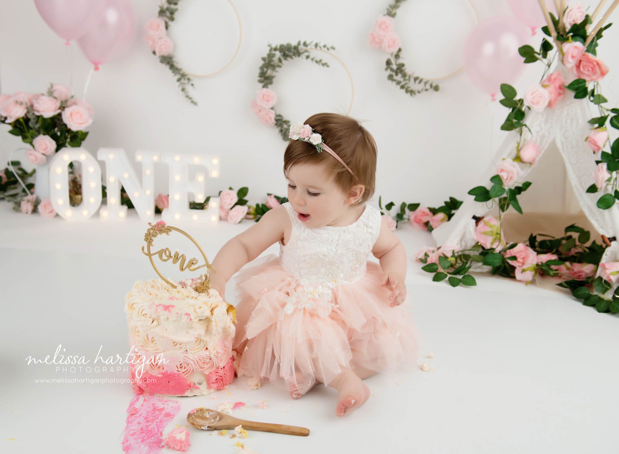 baby girl making mess during cake smash photoshoot