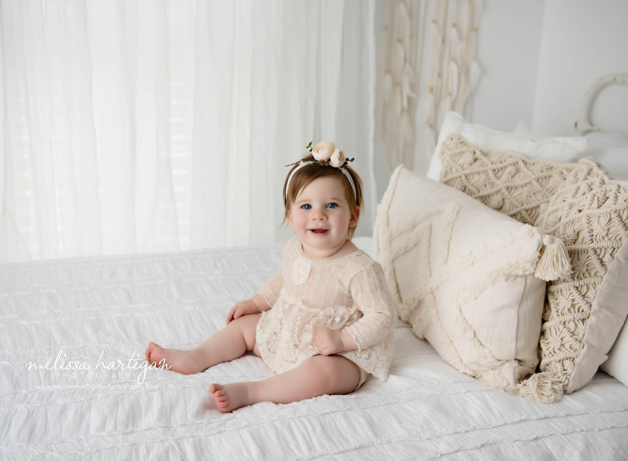 baby girl sitting on bed in photography studio west hartford baby photography