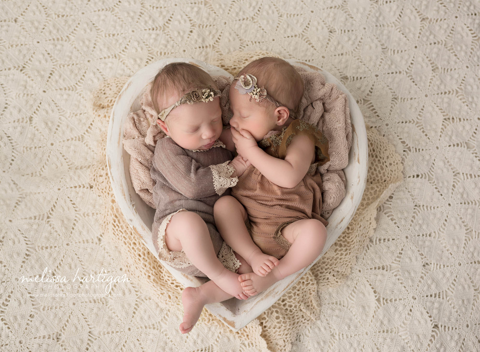 Twin baby girls posed in wooden cream bowl with boho layer wearing outfits and headbands west hartford CT newborn baby photography