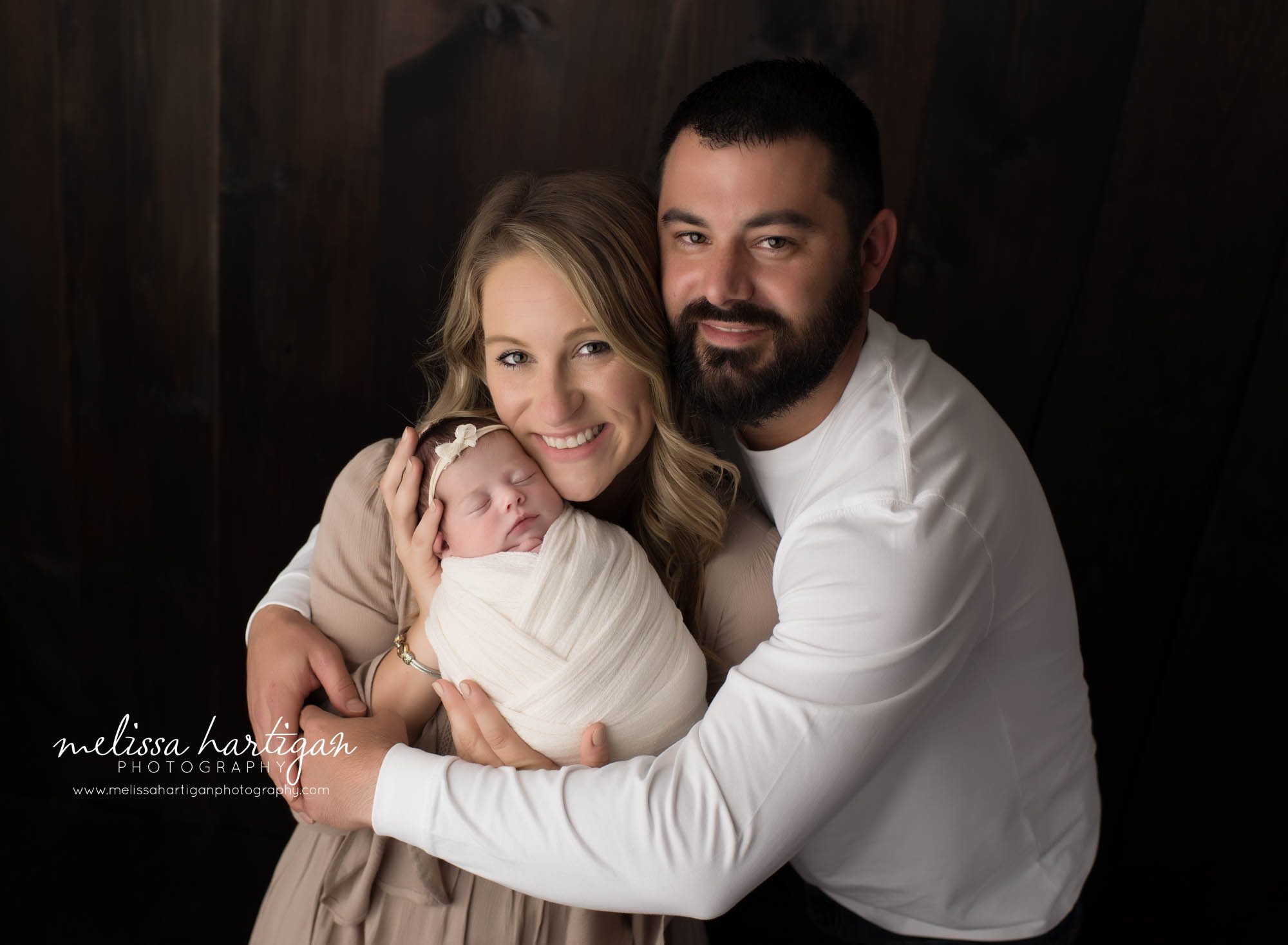 mom dad newborn baby daughter swaddled family parents pose