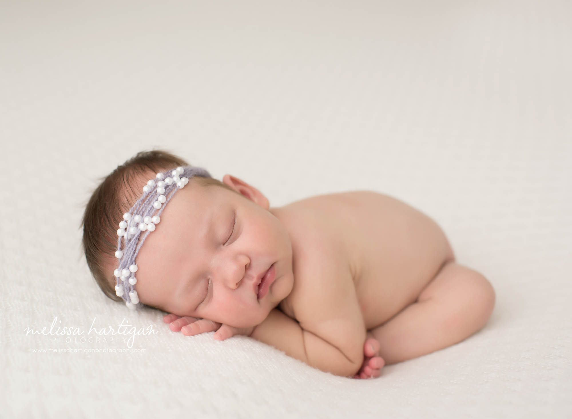 newborn baby girl posed modified taco pose wearing beaded headband tolland newborn photographer