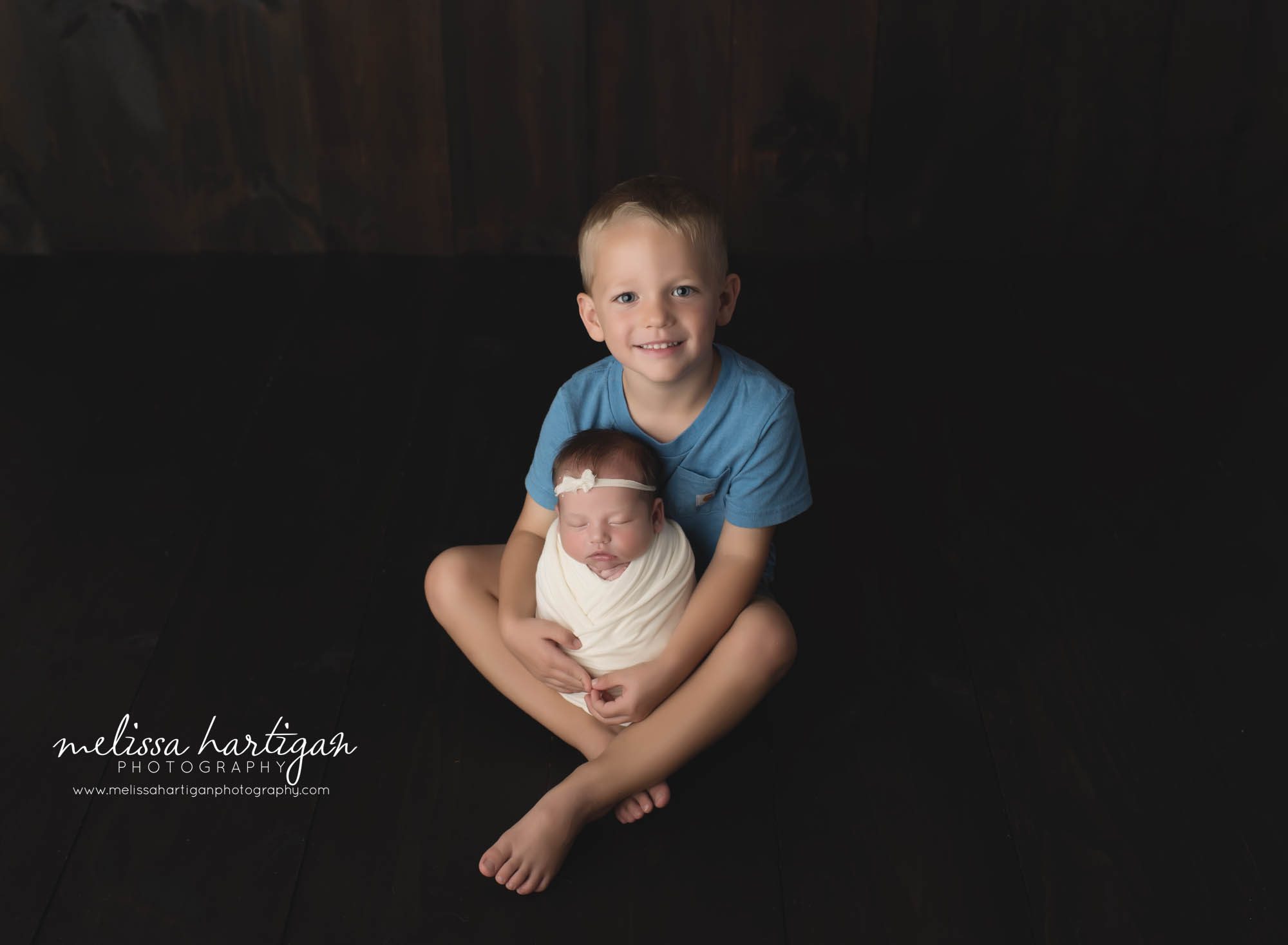 big brother holding newborn baby sister swaddled in cream wrap tolland CT newborn photography