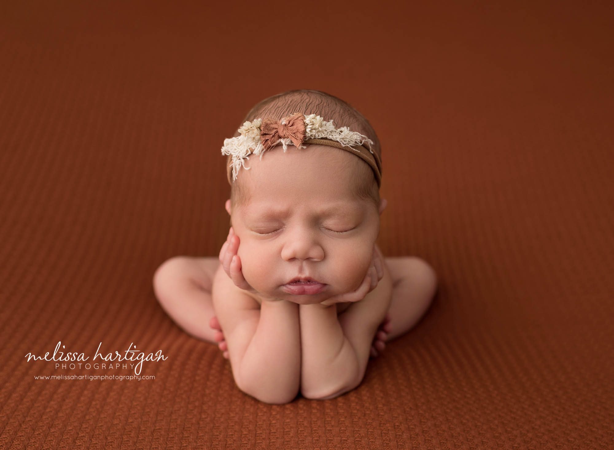 newborn baby girl posed froggy pose wearing floral headband west hartford ct newborn photography